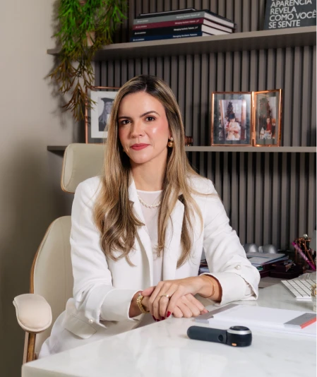 Dra. Bianca Almeida sentada à mesa do consultório