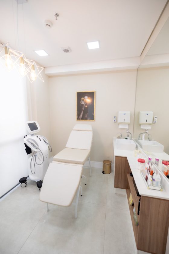 Sala da esteticista, com maca e aparelhos, no consultório da Dra. Bianca Almeida
